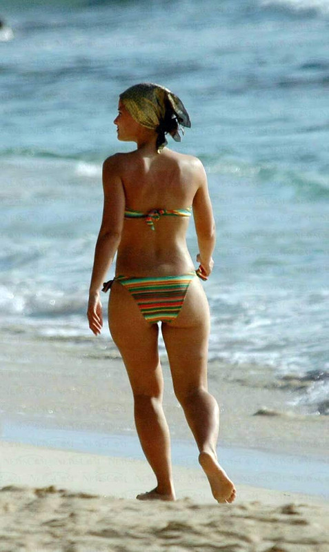 Med henne smal kropp och Svart hårtyp utan behå (kupstorlek 32B) på stranden i bikini

