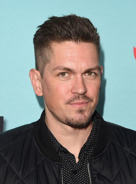 Cabelo castanho escuro e penteado boêmio de Steve Howey  em 2024