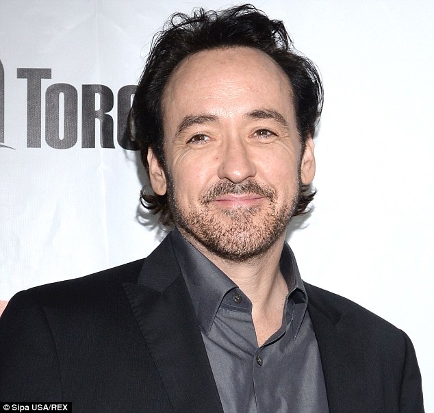 Cabelo preto e penteado formal de John Cusack  em 2024