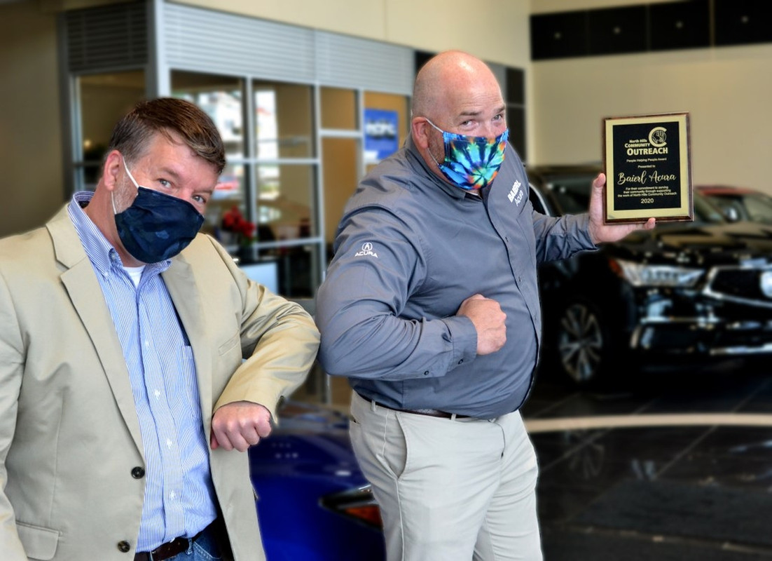 Baierl Acura Employee rubbing elbows with another Guest showing the award Off