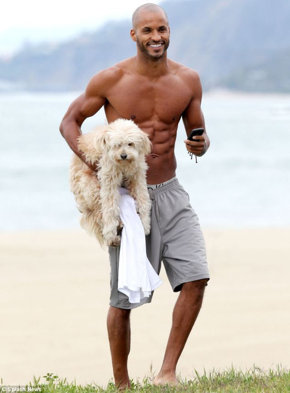 Com uma devoção
à incredulidade
,
 Capricórnio mostrando seu corpo nu, com forma muscular na praia
