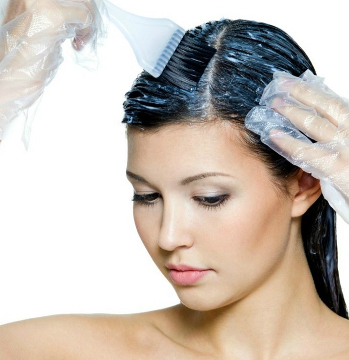 A black-haired woman dyes her hair