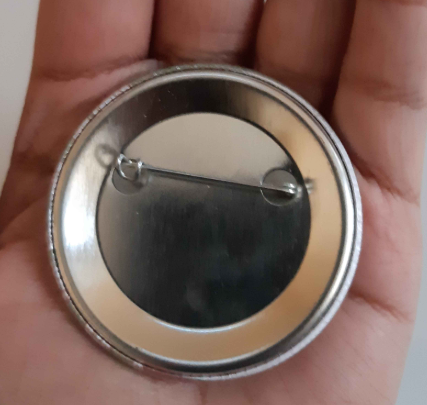 The back of one of the buttons; a simple metal backing with a pin across the top.