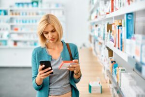 woman-using-app-on-mobile-phone-while-shopping-in-a-pharmacy-300×200.jpg