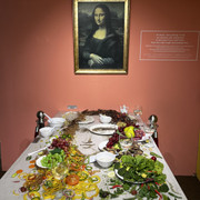 an illusion of the Mona Lisa on a table with elements of food