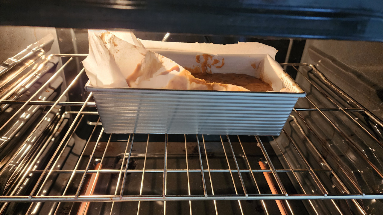 The banana bread ingredients, having been poured into a bread pan and placed into the oven.