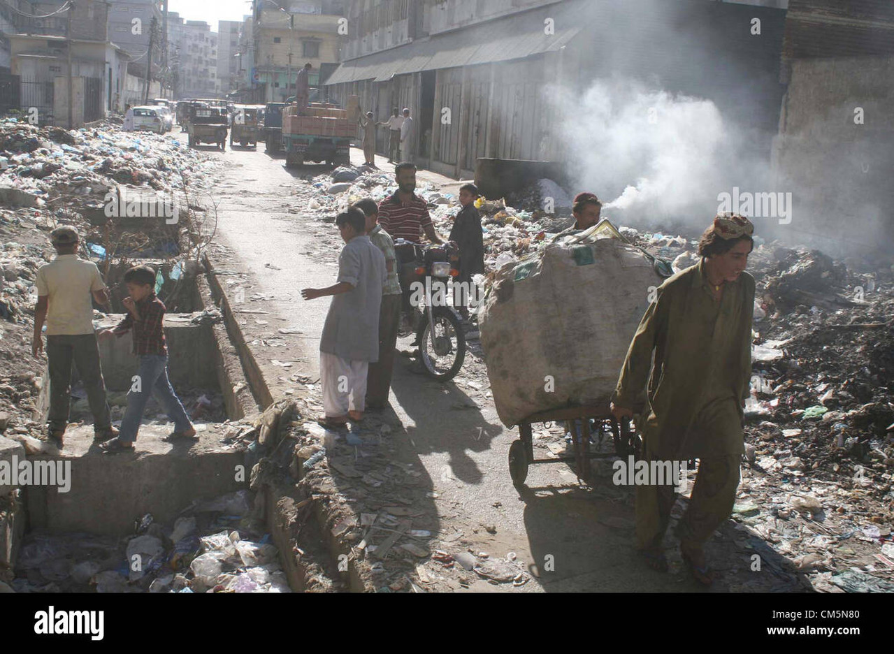 commuters pass through near an open sewerage drain and huge heap of CM5N80