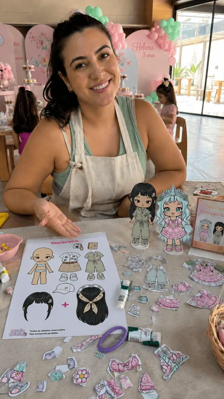 Mesa de festa infantil montada com bonecas de papel como atividade