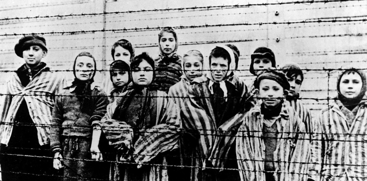 Foto de archivo tomada justo después de la liberación por parte del ejército soviético en enero de 1945, muestra a un grupo de niños tras la alambrada del campo de concentración nazi de Oswiecim, Auschwitz