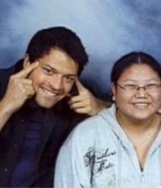 F. misha doing the "slanted-eyes" gesture next to an Asian woman