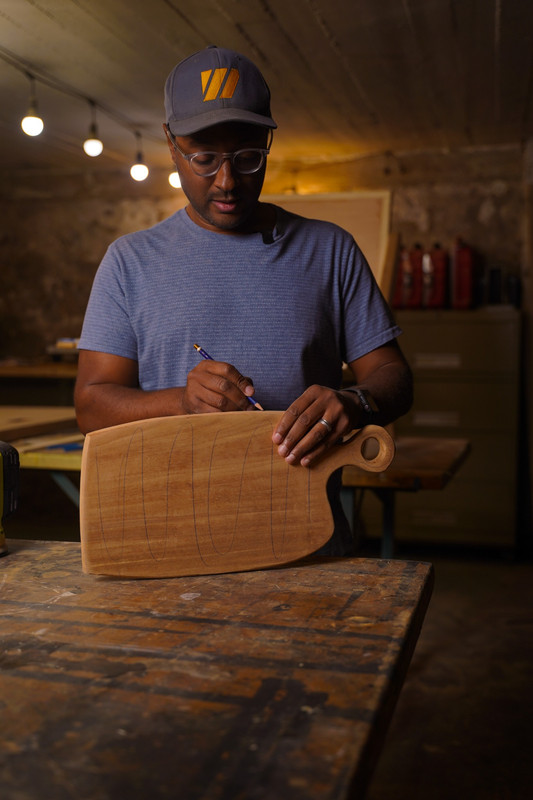Commercial industrial portrait photography of worker marking wood product in shop