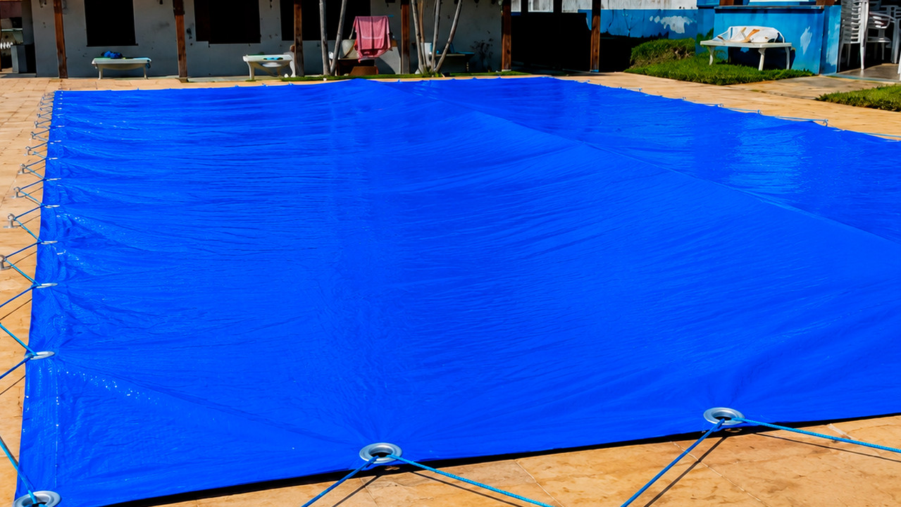 Floating bag applied under a pool cover to improve water drainage