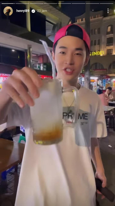 Momen Henry Lau pemer segelas es kelapa saat kulineran di sentra kaki lima.