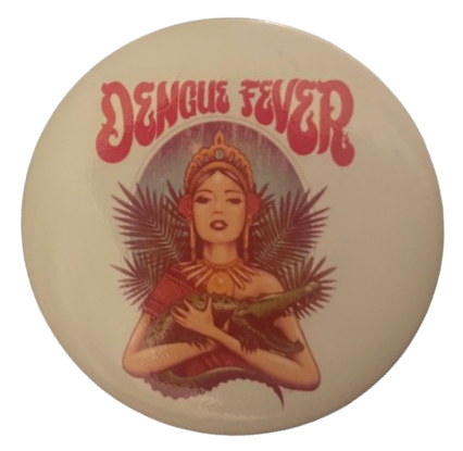 a dengue fever pin, in which a woman with a cool headdress on holds an alligator/crocodile in her arms, palm [?] leaves surrounding her, a blue circle behind her head, and the words 'Dengue Fever' above her