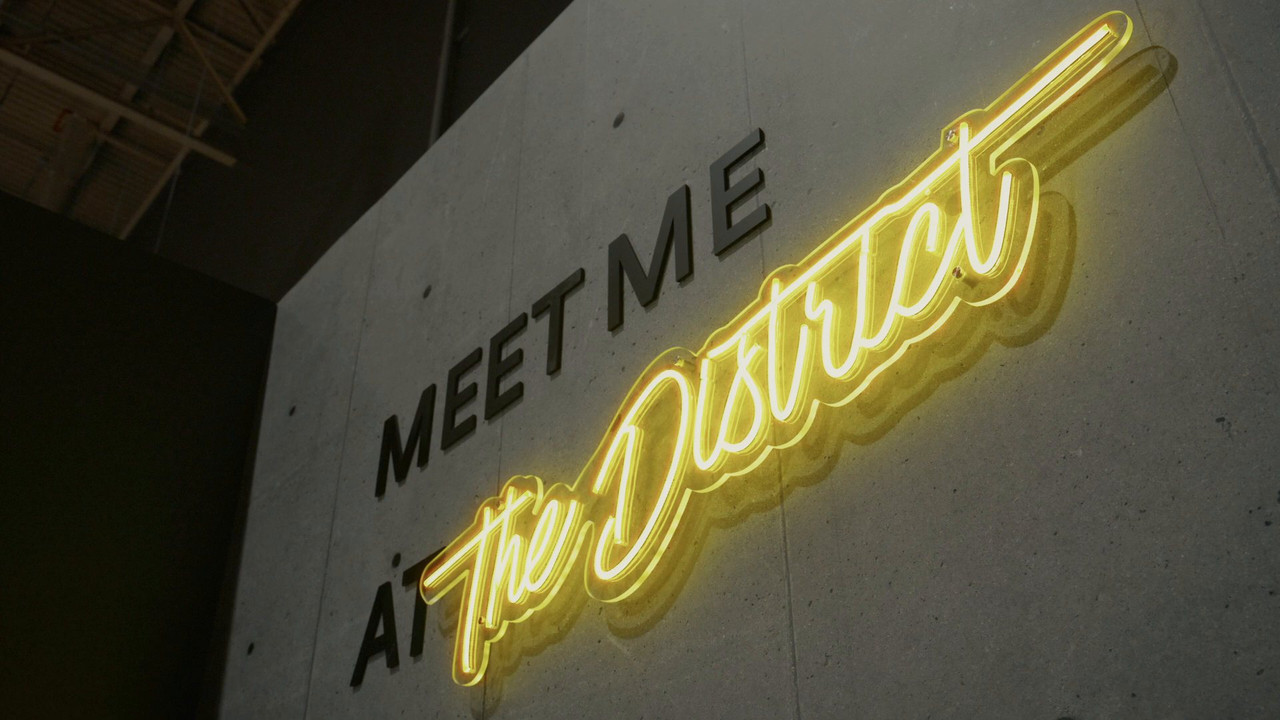 Neon Meet me at The District feature wall in the club lounge