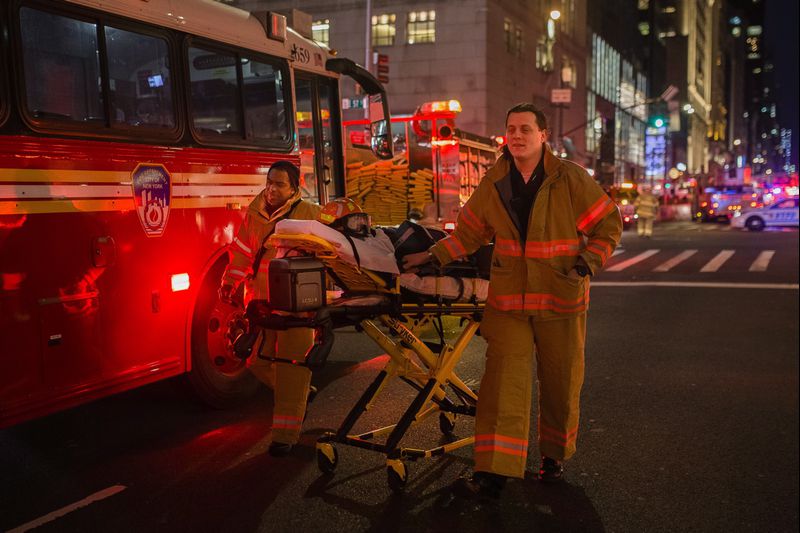 Emergency personnel rescuing injured person after a fire erupted in Trump Tower