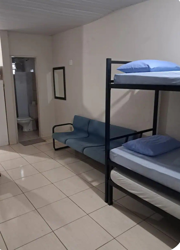 Interior da kitnet mobiliada em Campinas com cama e mesa