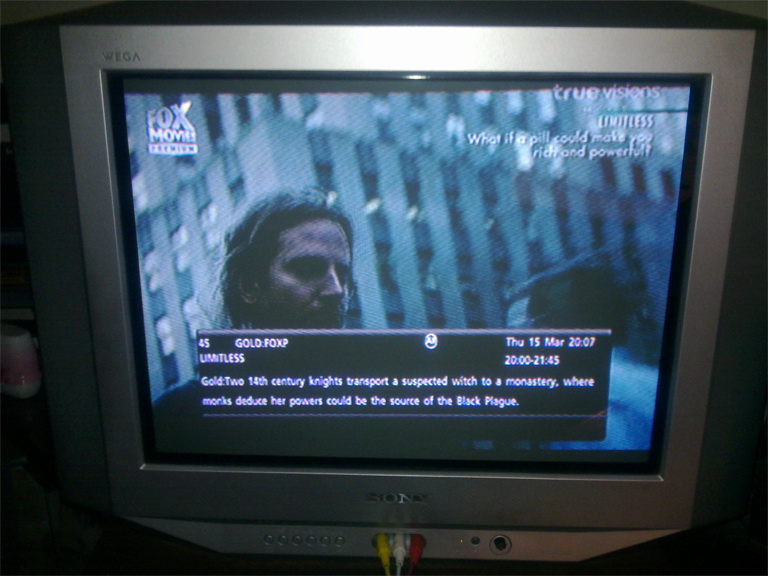 EPG over a scene from Limitless (logline under title bug: 'What if a pill could make you rich and powerful?'): 'Two 14th century knights transpost a suspected witch to a monastery, where monks deduce her powers could be the source of the Black Plague.'