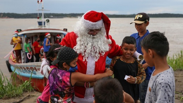 A lancha, Santa Claus lleva el espíritu navideño y regalos a niños en Brasil