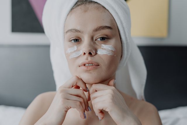 a woman applying moisturizer repair her skin barrier 