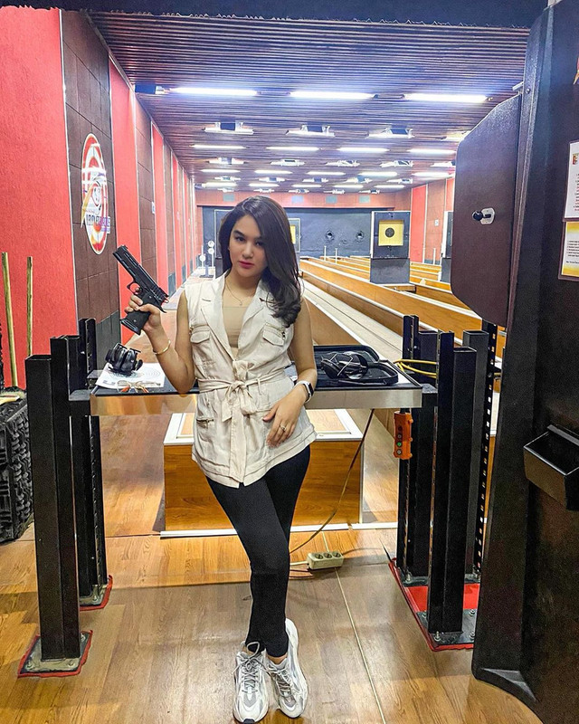 Hana Hanifa berpose dengan senapan ketika dirinya melakukan olahraga tembak.
