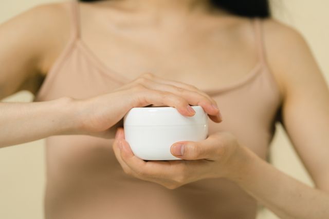 Woman holding a barrier-supporting moisturizer to soothe and protect the skin barrier.