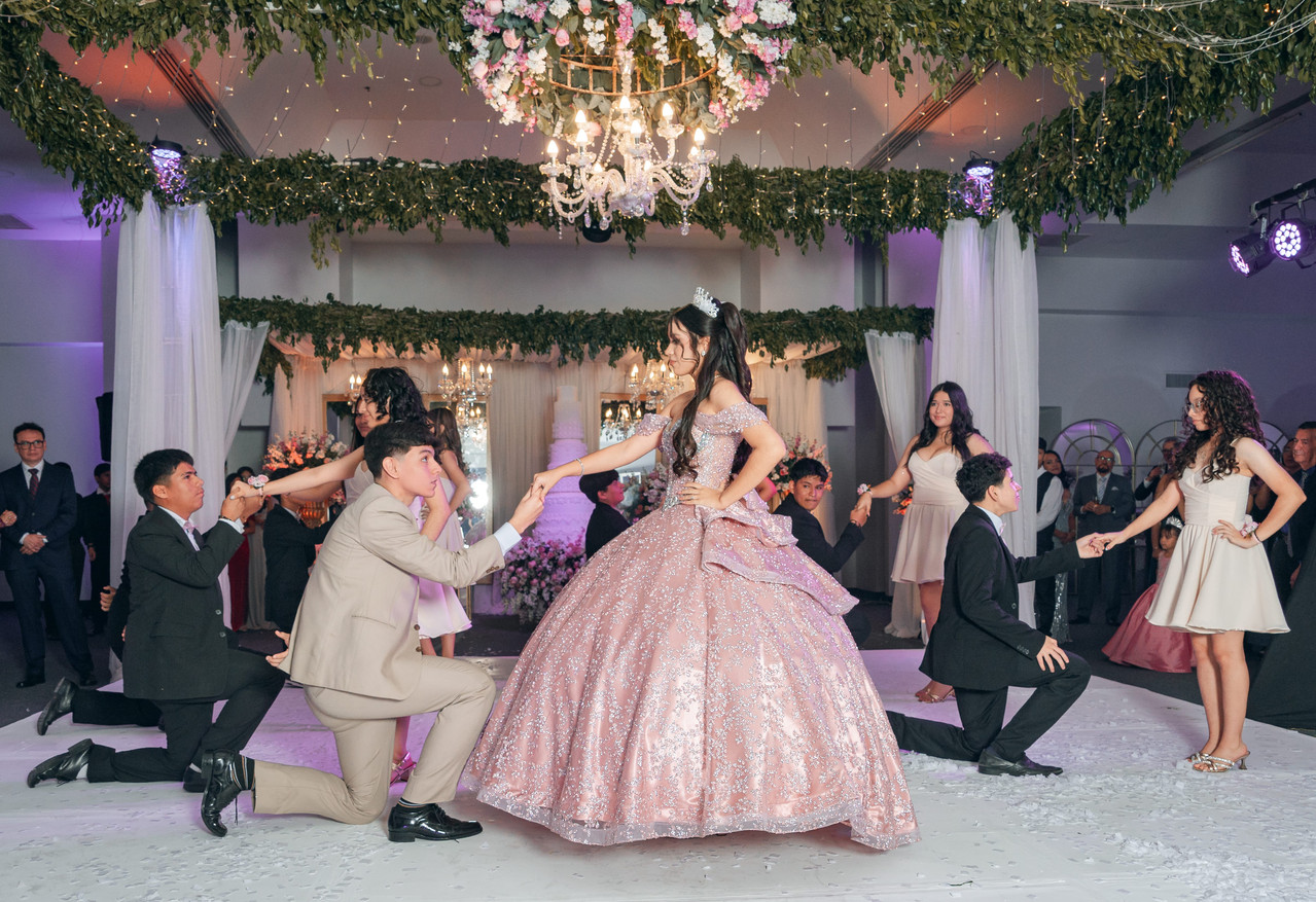Caballero arrodillado frente a la quinceañera durante la coreografía