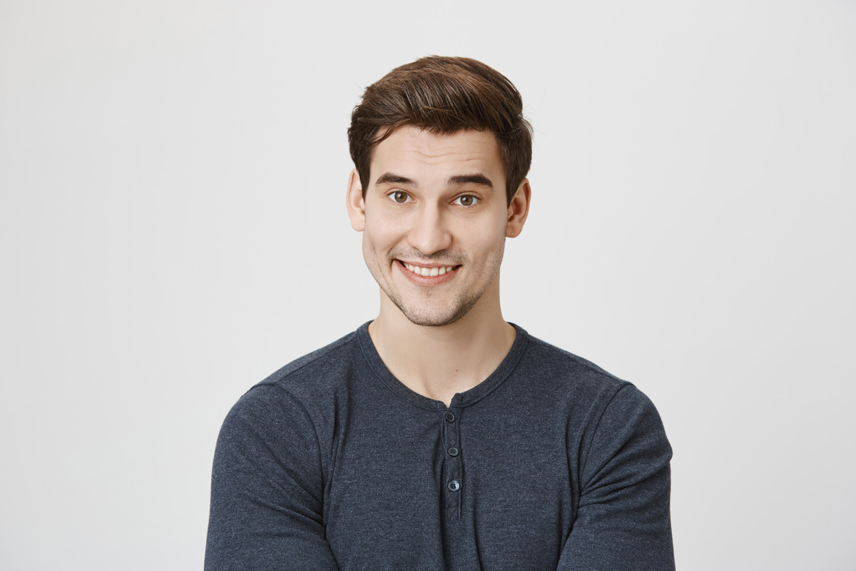 Waist up portrait of Caucasian handsome attractive young male with dark hair and stubble in casual c