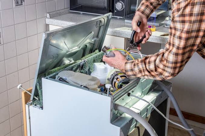 Refrigerator repair technician at work