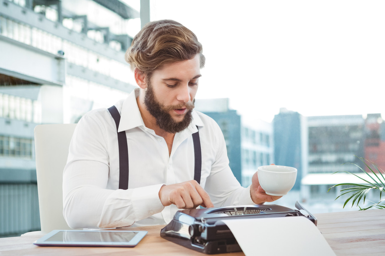 worker using typewriter while having coffee