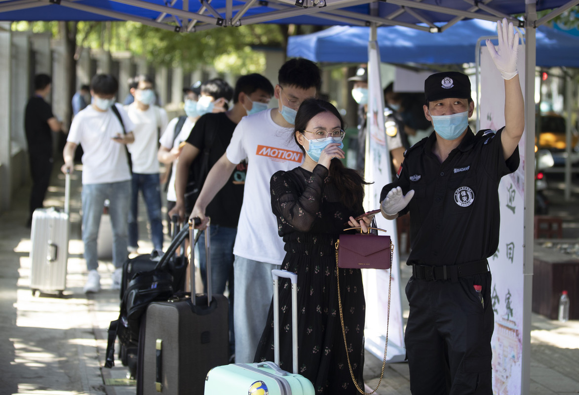 Siswa menunggu untuk diperiksa sebelum memasuki Universitas Wuhan, pada hari pertama kelas di Wuhan pada 8 Juni 2020. Siswa tahun terakhir kembali ke kampus di Wuhan setelah universitas dibuka kembali setelah penutupan selama berbulan-bulan karena coronavirus.