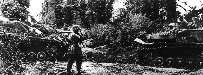Blindados de cañón autopropulsados Sturmgeschütz IV pertenecientes a la 17ª División SS de Granaderos Götz Von Berlichingen en Francia, 1944, se camuflan para lanzar una emboscada contra el enemigo estadounidense