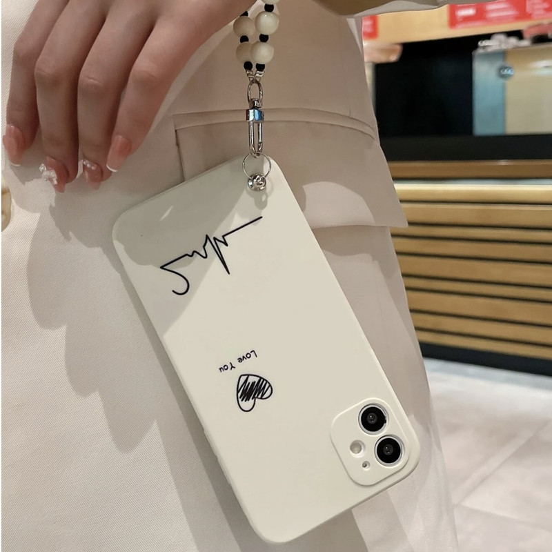 Foto de Funda beige con diseño de corazón. Incluye correa de mano.