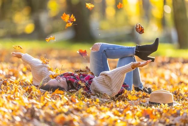 carefree-beautiful-brunette-lying-park-throws-away-fallen-leaves-during-sunny-autumn-sunset-341862-1.webp