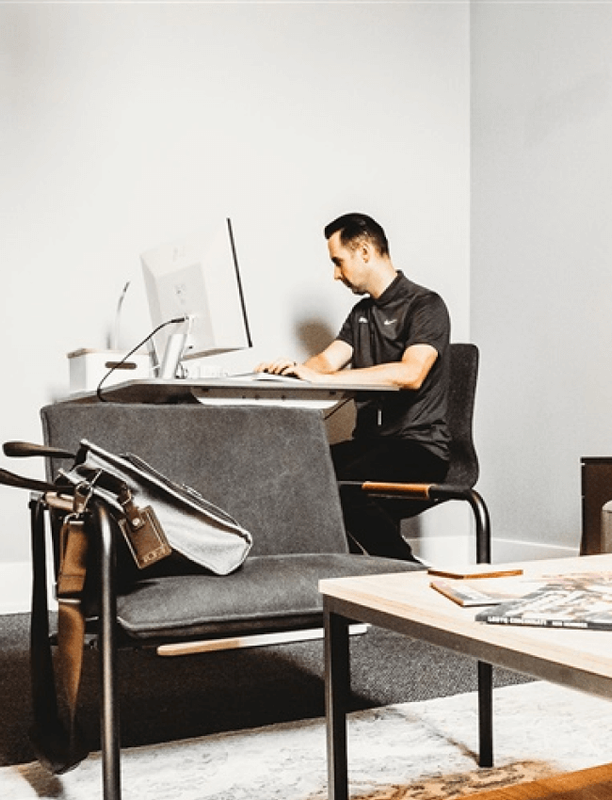 Small group collaborating around a table in a bright coworking area near windows.