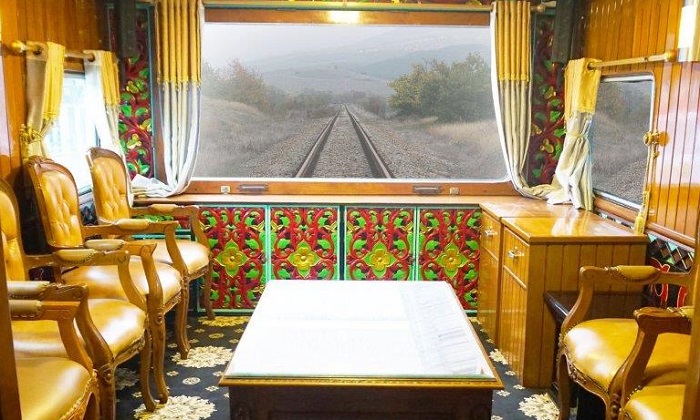 Ruangan balkon VIP di Kereta Wisata Nusantara yang dilengkapi dengan jendela besar.