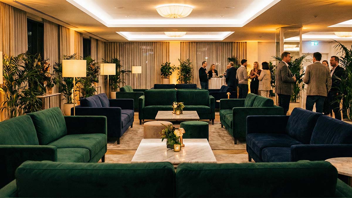 Стильная лаунж-зона на мероприятии с бархатными диванами, теплым светом и живыми растениями.
