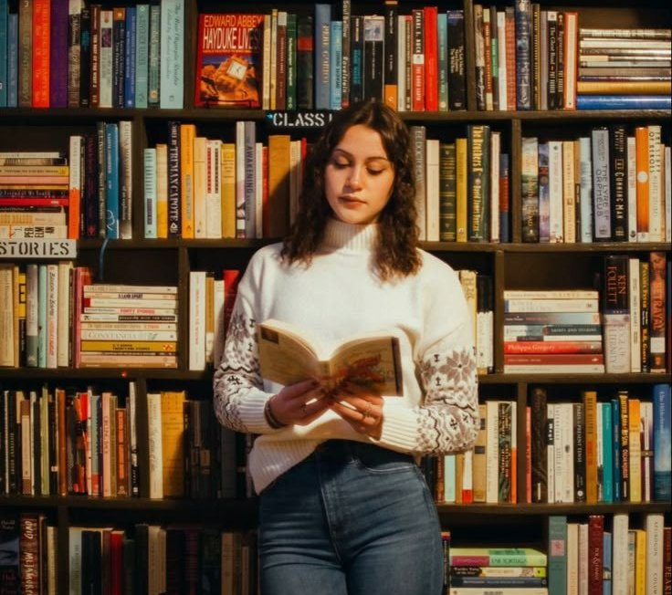 Leitora lendo livro com atenção na biblioteca representando a consolidação dos hábitos de leitura e escrita