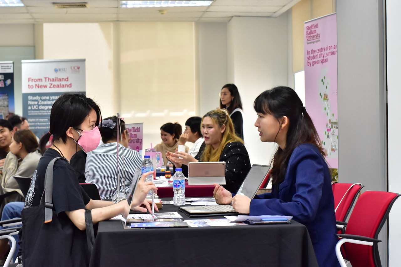 Visitors speaking with study abroad advisors at RSU event