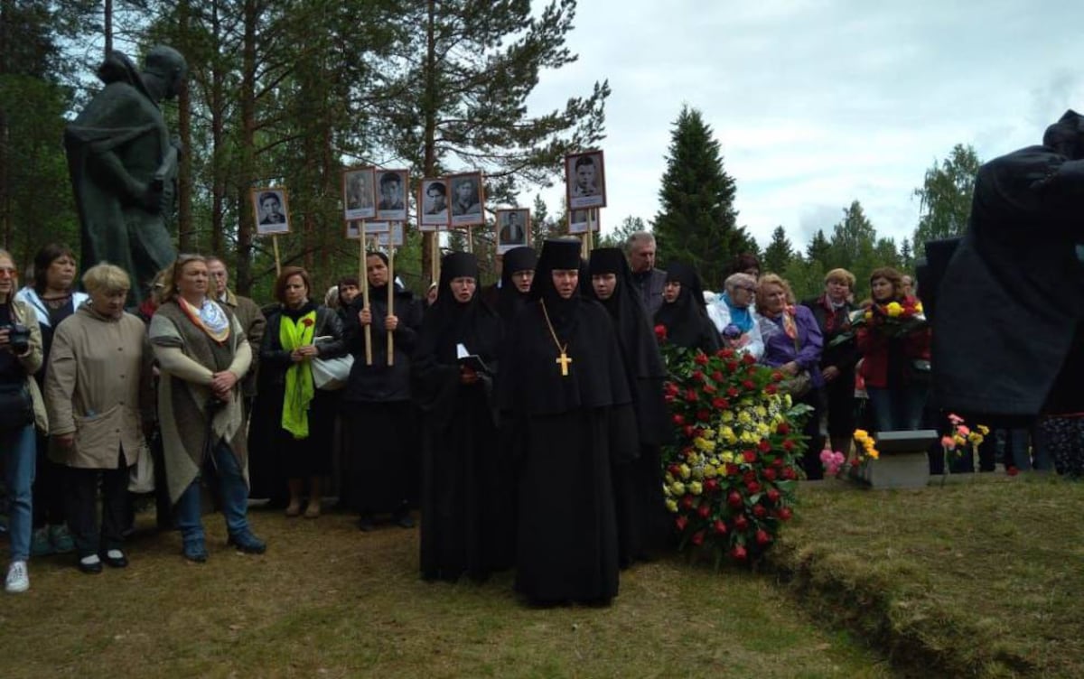 Las monjas marchando con los retratos de los españoles hacia el monumento