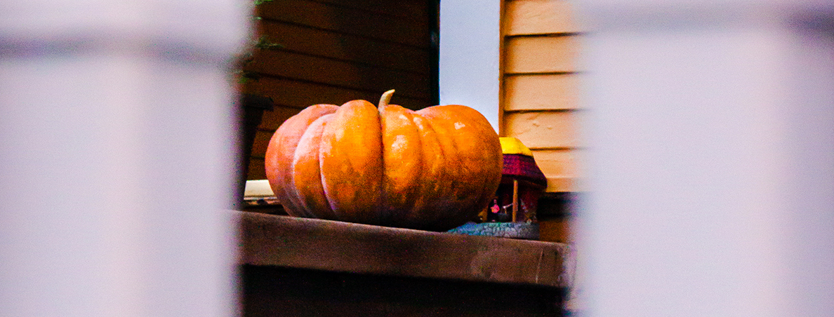 A pumpkin sitting on a front porch.