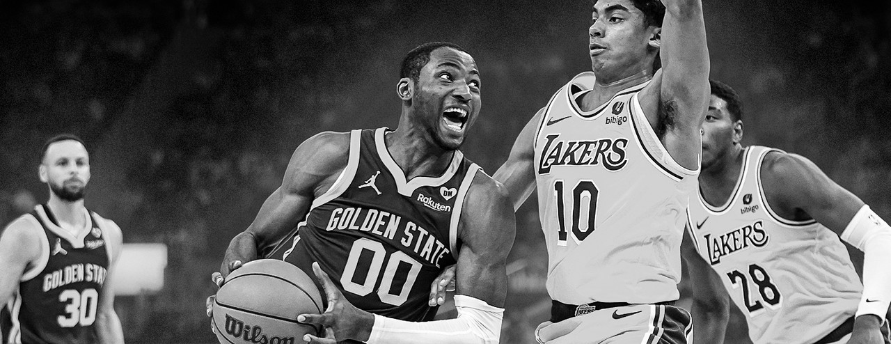 Jonathan Kuminga do Golden State Warriors atacando a cesta contra o Los Angeles Lakers, driblando um defensor enquanto exibe intensidade e força.