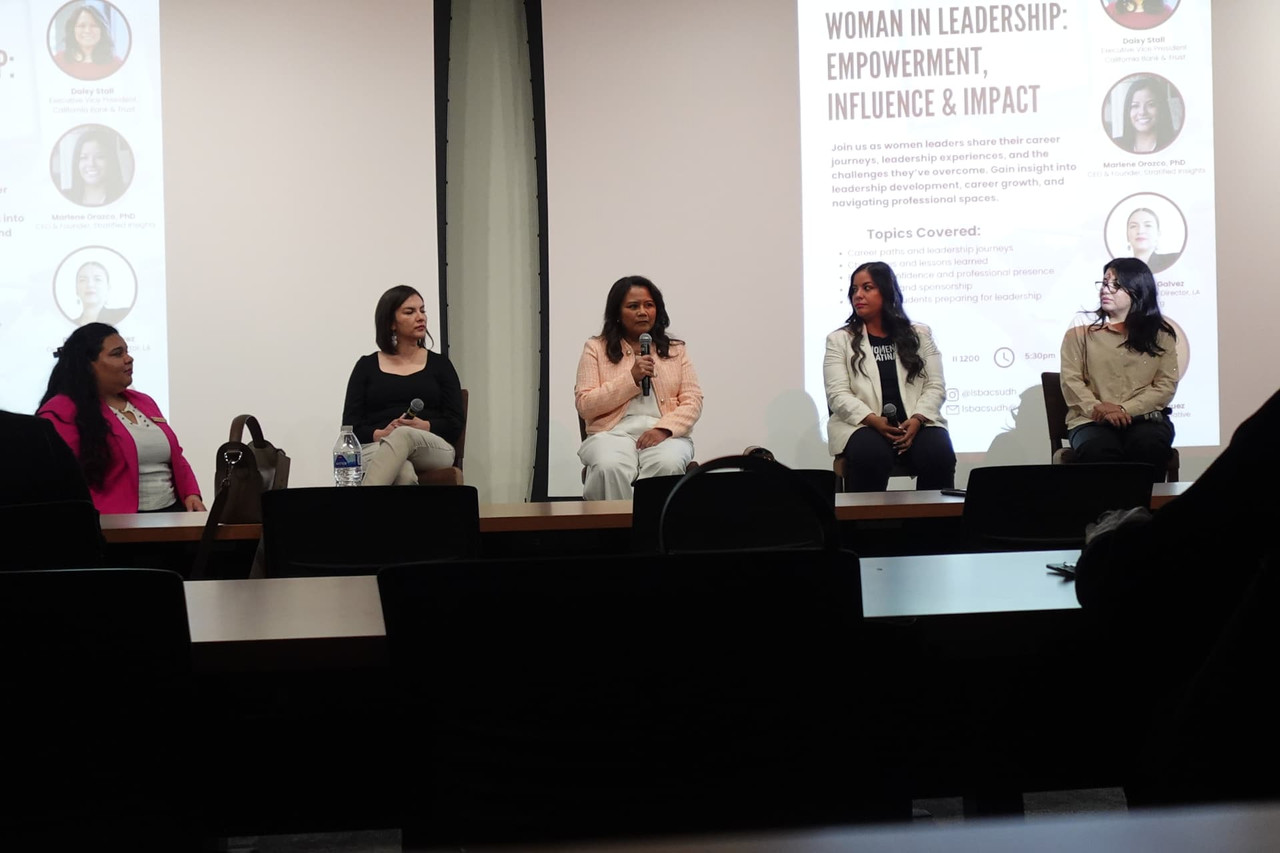 Women in Leadership panel speakers seated at the front of the room.