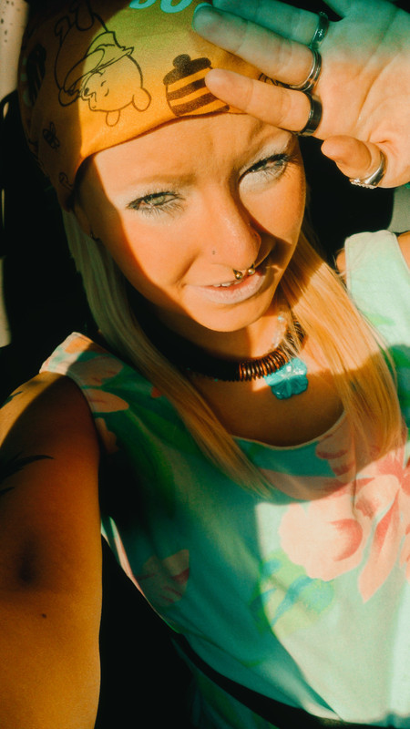 a selfie of Ray in the bright sunlight, with their hand up mimicking an old EGG magazine cover