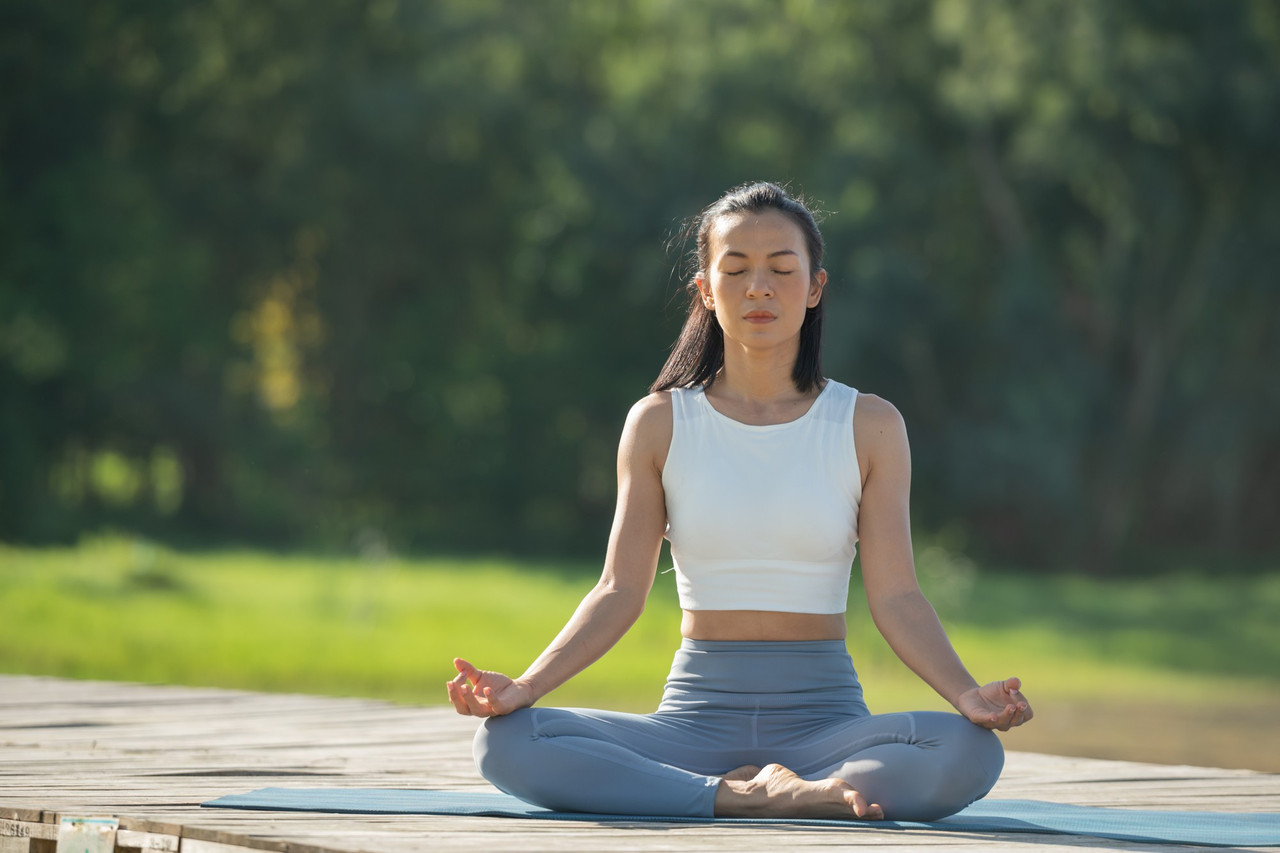 Person meditating serenely by a lake