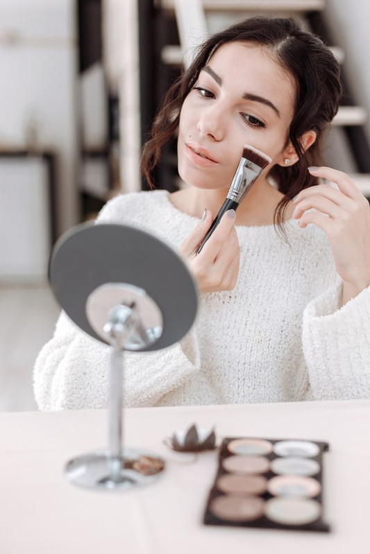 a woman applying foundation in dabbing motion to apply foundation with the right technique 