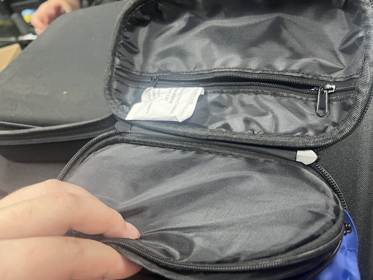 Custom hard EVA insulin cooler case open on a wooden table, showing a middle divider panel with elastic straps holding insulin pens, a dedicated ice pack compartment, and internal mesh pockets in a warm home background.