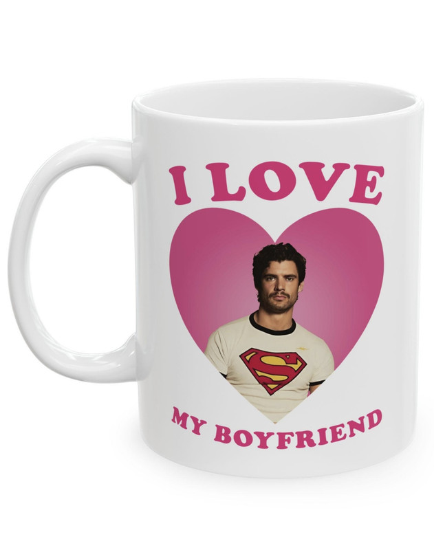 White ceramic mug with a photo of David Cornswet wearing a Superman t-shirt in a pink heart, surrounded by the words "I love my boyfriend"