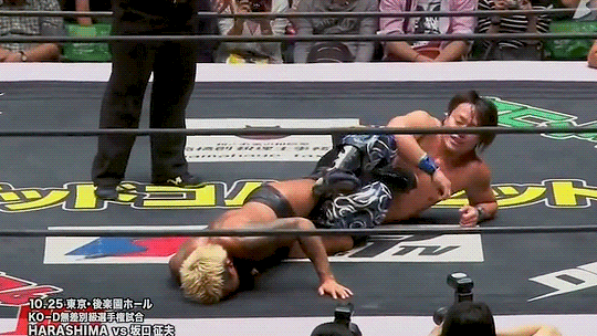 GIF of DDT Special 2015. HARASHIMA has Yukio Sakaguchi in a figure-four leg lock. HARASHIMA moves his right leg to push against Sakaguchi's bent left leg, putting pressure on the trapped limb. Sakaguchi yells in pain.