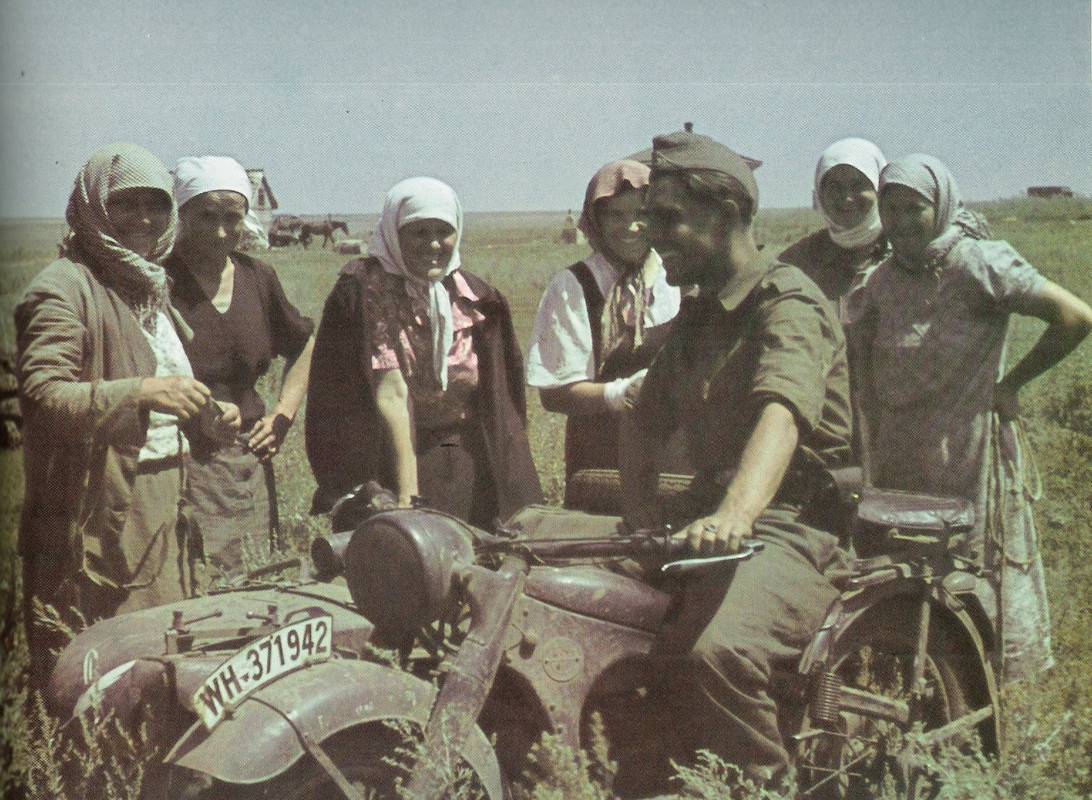 Немецкий военный корреспондент разговаривает с украинскими женщинами в поле. На коляске мотоцикла BM